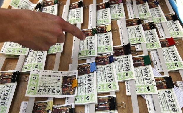 Una persona elige un décimo de la Lotería Nacional en un puesto. /Javier Lizón (Efe)