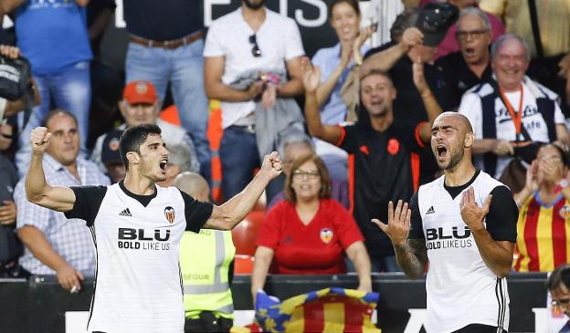 Dúo letal. Guedes, a la izquierda, y Zaza celebran el primer tanto del atacante portugués al Sevilla el sábado en Mestalla. / EFE/Kai Försterling