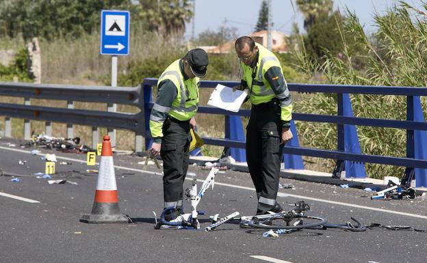 Dos guardias civiles observan una bicicleta destrozadas tras un accidente. /EFE/Natxo Francés