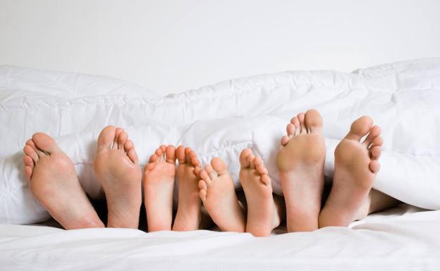 Cuatro personas comparten cama.
