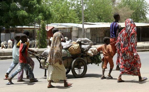 Varias personas avanzan con sus pertenencias en Borno. /Reuters
