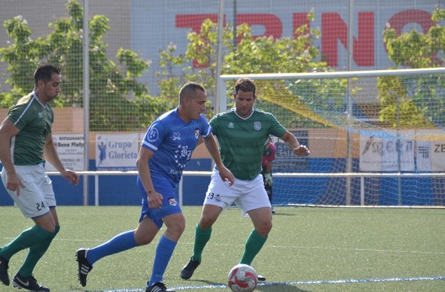 Un jugador del Kamarca Dénia disputa el balón ante dos rivales en un lance del partido.