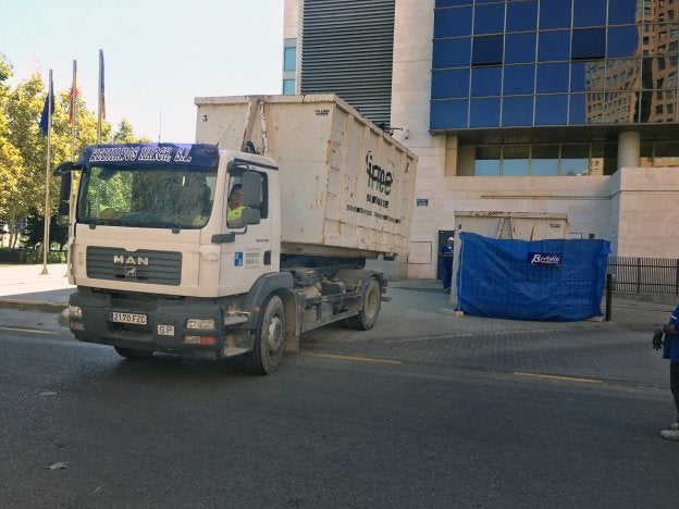 Un camión traslada el contenedor con decenas de sillas calcinadas.