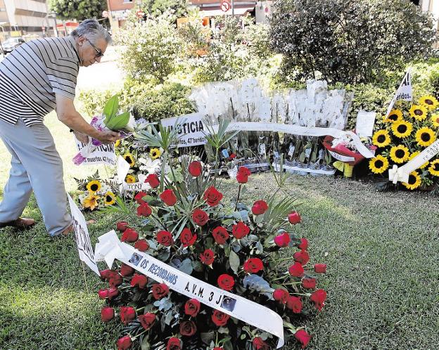 Un hombre coloca flores en recuerdo a las víctimas. / j. Cardenas/efe