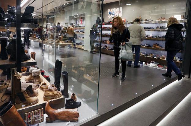 Compradores en un pequeño comercio de la ciudad de Valencia. / Jesús Signes