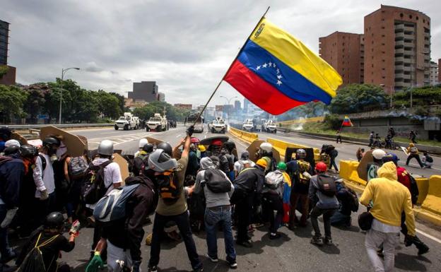 Enfrentamiento entre decenas de manifestantes y la Guardia Bolivariana en Caracas./Miguel Gutiérrez (Efe)