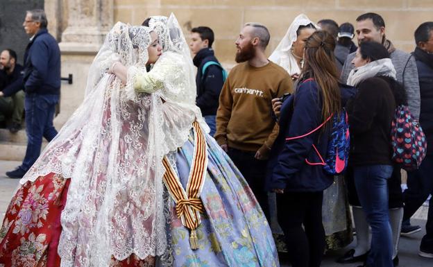 Dos falleras se abrazan durante la Ofrenda.