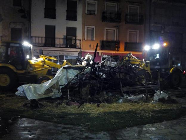 Las máquinas trabajando en plena noche para la retirada de los restos de la cremà en uno de los monumentos de Gandia. / lp