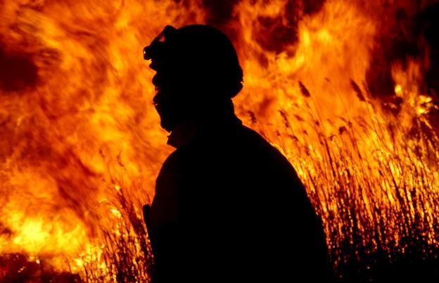Un bombero del Consorcio Provincial de Castellón durante las tareas de extinción del fuego en el Prat de Cabanes. / siab