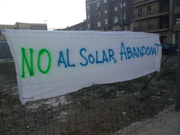 Una pancarta en el solar junto al centro educativo. / lp