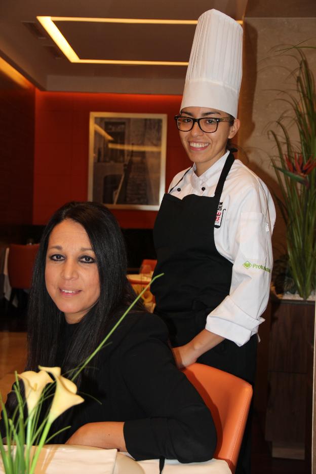Elena Gutiérrez, sentada,
y detrás la cocinera
de Ameyal, Karla Chápero./