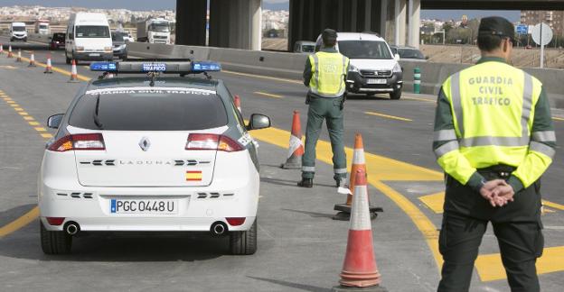 Dos agentes de la Guardia Civil vigilan el tráfico en la V-30, ayer, al inicio de la operación especial de Semana Santa. / damián torres