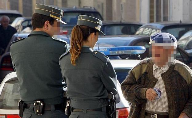 Unapareja de guardiacivilles habla con un anciano. /LP