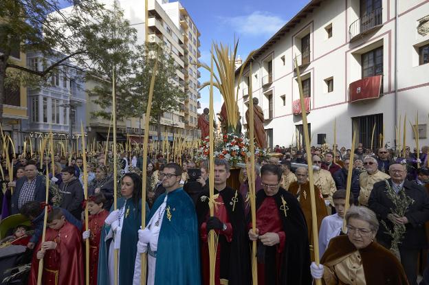 Concentración de cofrades con palmas en la plaza Escoles Pies de Gandia. / Natxo francés