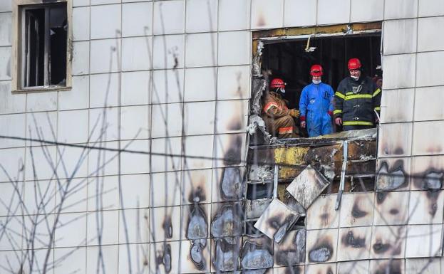 Bomberos en el centro comercial incendiado./Afp