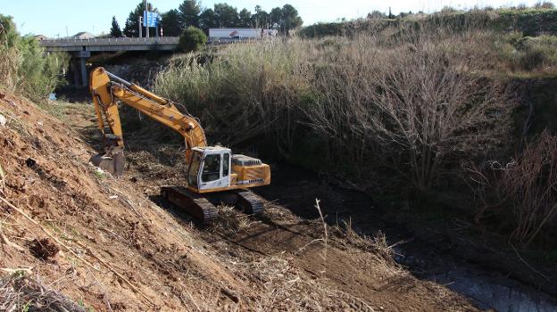 Una máquina limpia el cauce del barranco. / lp