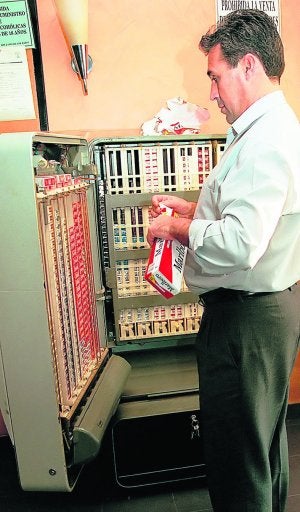 El propietario de un bar repone la maquina de tabaco. ::
M. BATROLOMÉ/