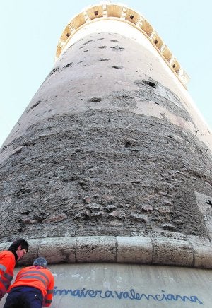 Dos operarios intentan limpiar la pintada en las Torres de Quart. / Kai Försterling
/ Efe/