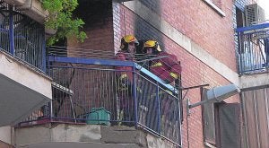 Dos bomberos, ayer, en un balcón del edificio donde se registró el incendio. / LP/