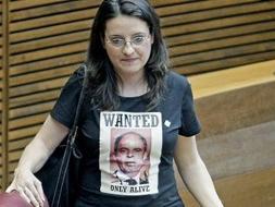 La portavoz del grupo Compromis en Les Corts Valencianes, Mónica Oltra, a su llegada esta mañana al pleno vistiendo una camiseta con una fotografía del presidente de la Generalitat, Francisco Camps, y el lema en inglés "Se busca. Sólo vivo", hecho por el que la presidenta de Les Corts Valencianes, Milagrosa Martínez, la ha expulsado del pleno. EFE/