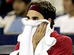 Federer se tapa la cara con una toalla en su partido ante González./