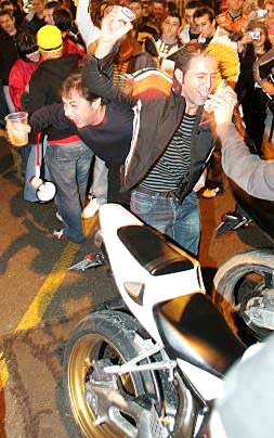 Varios jóvenes disfrutan de la fiesta con motos por el medio./