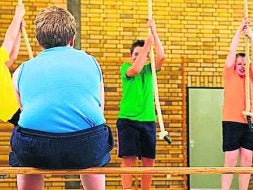 Un niño obeso observando a sus compañeros de colegio. /lp/