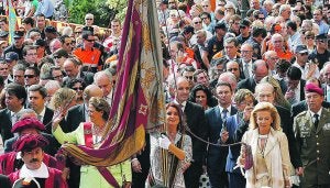 La concejala Mercedes Caballero porta la Real Senyera acompañada por las autoridades. / IRENE MARSILLA/