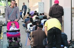 CALLE COMPARTIDA. Fieles de la mezquita de Torrent rezan en la acera, ayer a mediodía, junto a varios transeúntes. / DAMIÁN TORRES/
