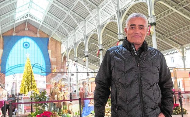 Osman Korkar, egiptólogo, junto al belén y el árbol de Navidad del mercado./Damián Torres