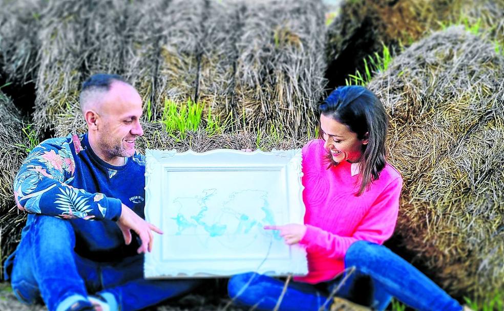 Los valencianos Paco Castelló y Gina Pérez señalan en un mapa dibujado a mano el sur de Tailandia, donde les aguarda desde primeros de mayo Ian, un niño de dos años./Saúl castelló