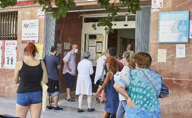 Varios pacientes esperan en la puerta para ser atendidos en el centro de salud Joaquín Benlloch de Valencia. /Iván Arlandis