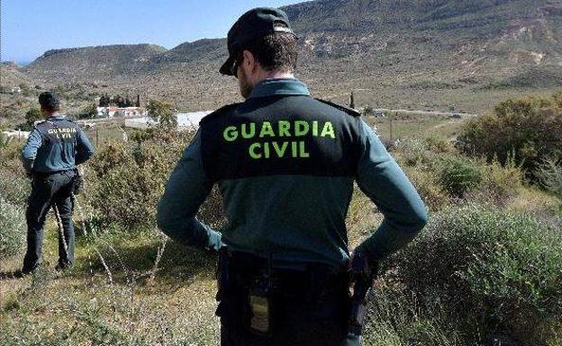 Dos guardias civiles realizan una batida en una zona de monte. /EFE