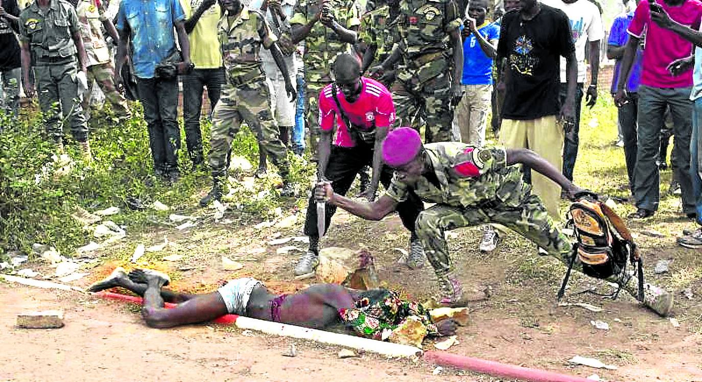 Un soldado apuñala el cadáver de un adolescente que fue acusado de pertenecer a un grupo insurgente