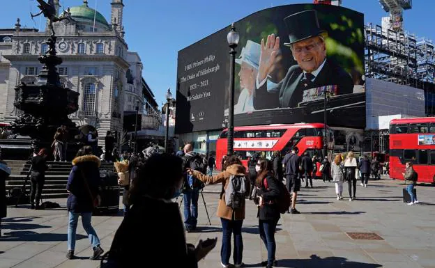 Una imagen de gran tamaño de Felipe de Edimburgo y la reina Isabel preside Piccadilly Circus, en el centro de Londres. /AFP