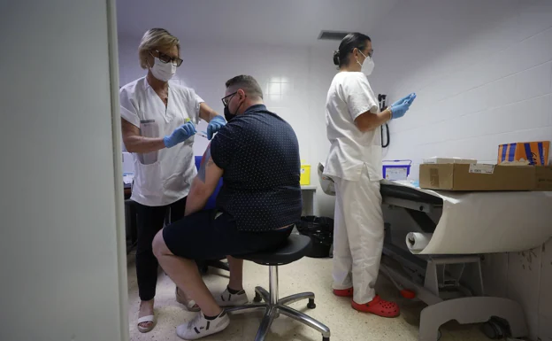 Unos trabajadores de la salud vacunan a un paciente. 