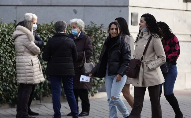 Un grupo de personas camina por la calle. 